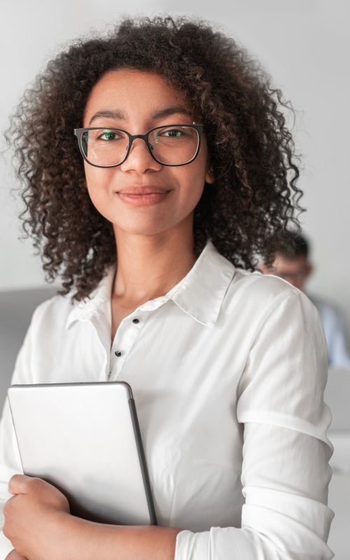 smiling ethnic female recruiter with tablet looking at camera in office